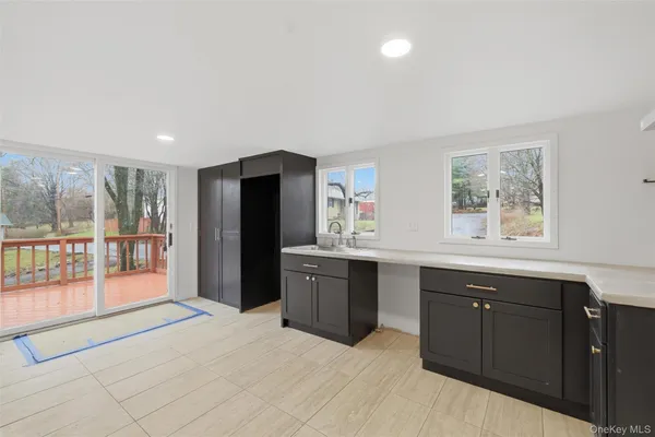 a spacious bathroom with a granite countertop sink a large mirror a bathtub and window