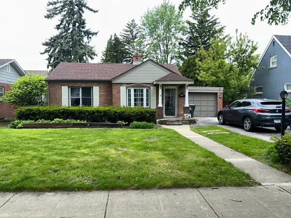 a front view of a house with a garden and trees
