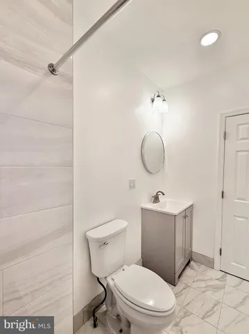 a bathroom with a toilet and a mirror