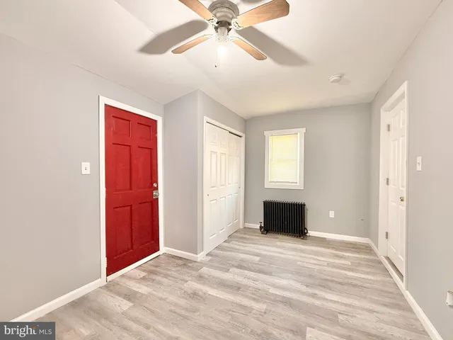 a view of an empty room with a ceiling fan and window