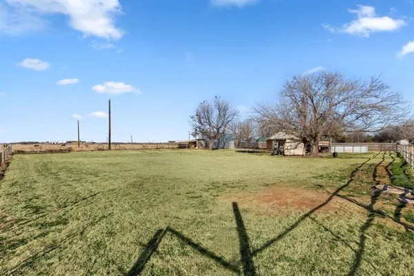 a view of yard with green space and trees