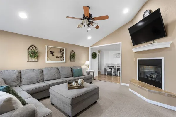 a living room with furniture a flat screen tv and a fireplace