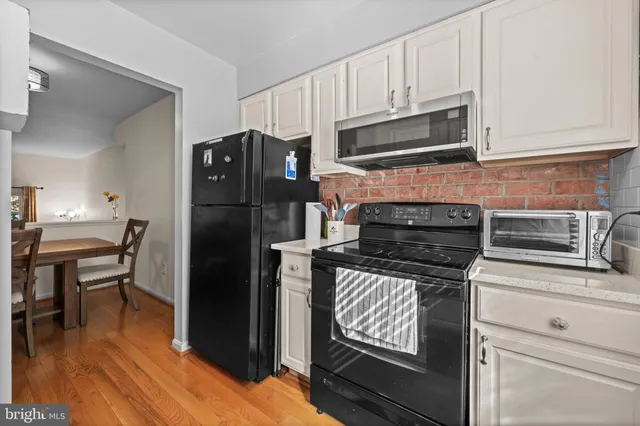 a kitchen with granite countertop a refrigerator stove and microwave