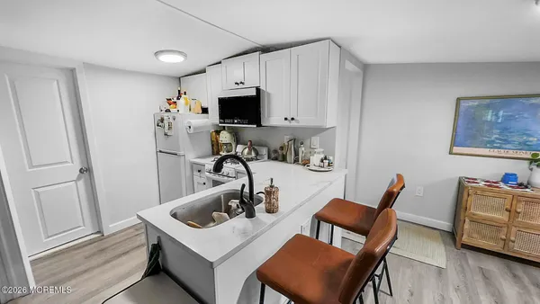 a kitchen with stainless steel appliances kitchen island a table chairs and a refrigerator