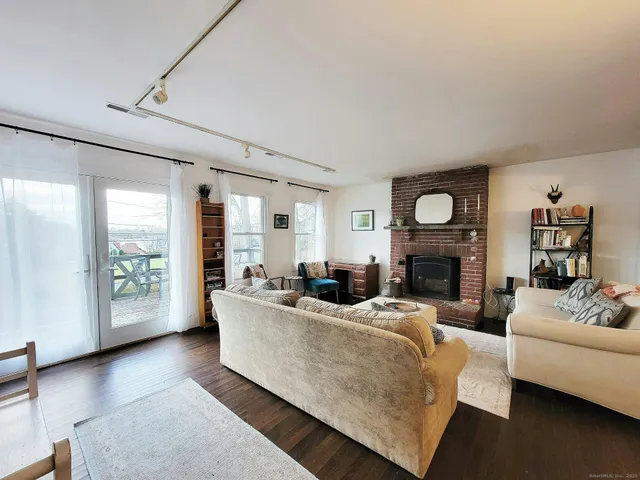 a living room with fireplace furniture and a large window