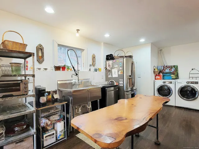 a kitchen with stainless steel appliances kitchen island a table chairs stove and refrigerator