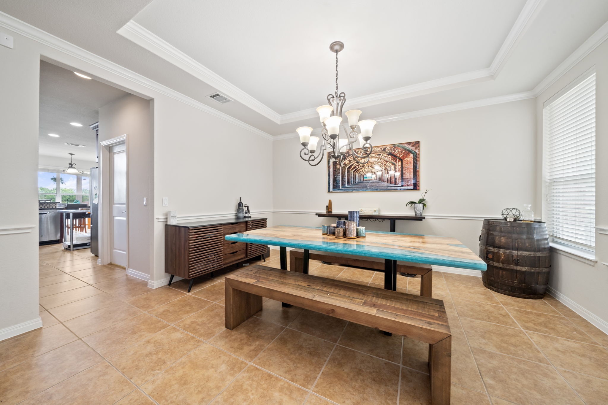 1581 Grassy Field Road Austin, TX 78737 - Photo 15 of 37 Elegant crown molding and tray ceiling detail elevate this formal dining space with tile flooring.