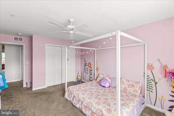 a bedroom with a bed chandelier and a window