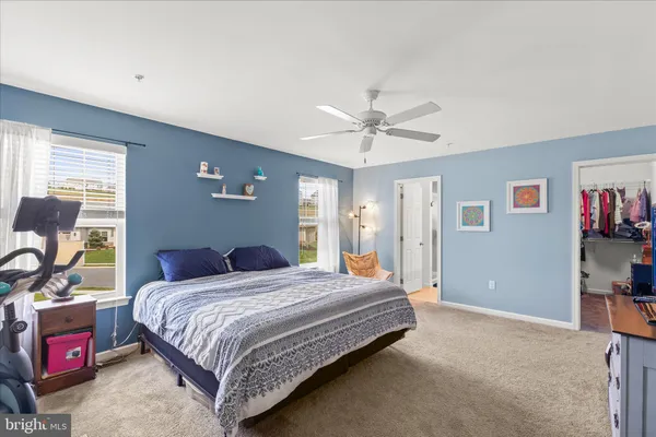 a bedroom with a bed a dresser and book shelfs