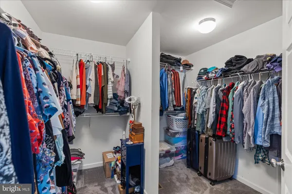 a view of walk in closet with clothes