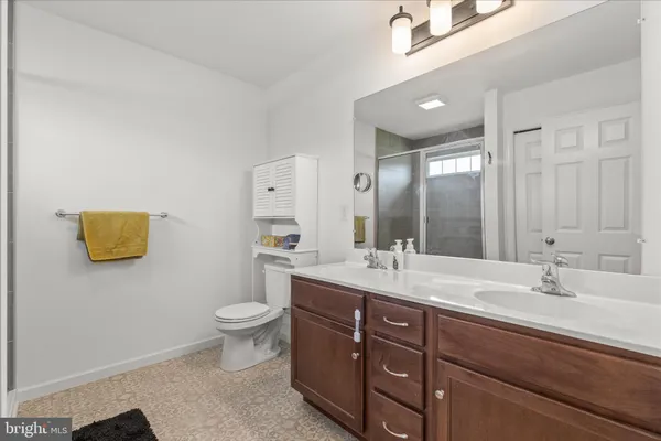 a bathroom with a double vanity sink toilet and a mirror