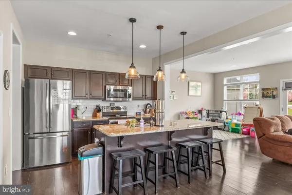 a kitchen with a refrigerator a dining table and chairs