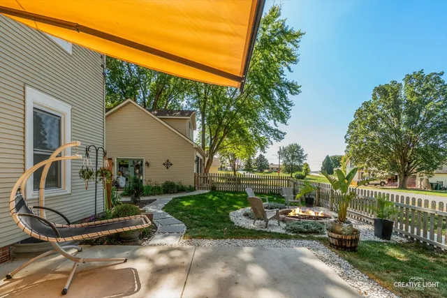 a view of a chair and table in backyard of the house