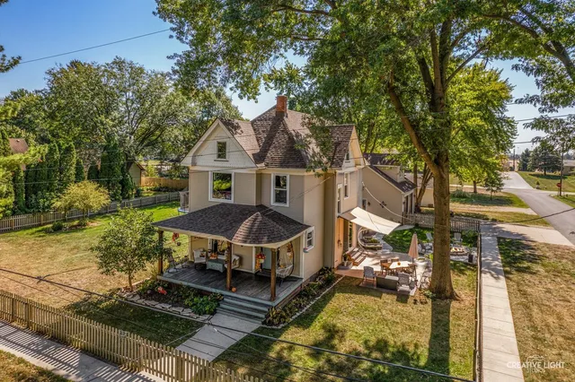 an aerial view of a house with swimming pool and large trees
