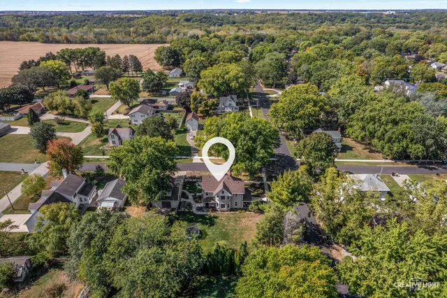 an aerial view of residential house with outdoor space and trees all around