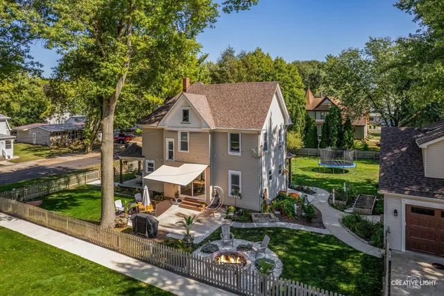a view of a chair and table in backyard of the house