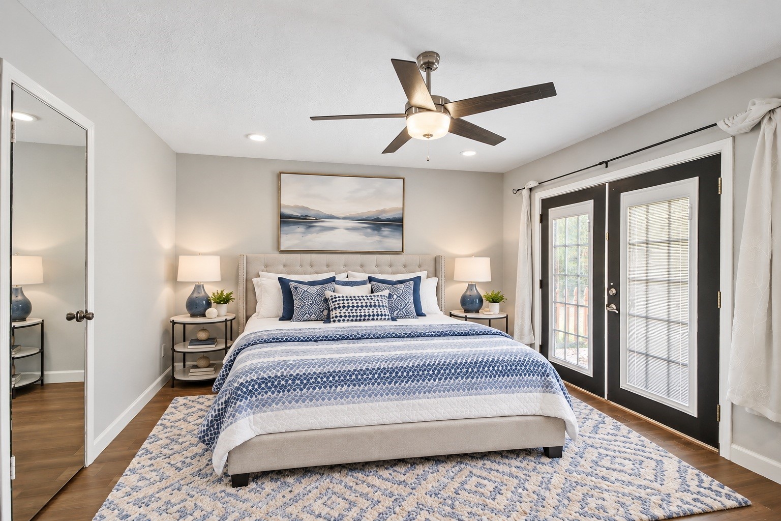 3527 Eula Morgan Road Katy, TX 77493 - Photo 8 of 23 The primary bedroom offers a spacious retreat with dark wood-look flooring, a ceiling fan, and French doors that bring in plenty of natural light. Virtually staged.