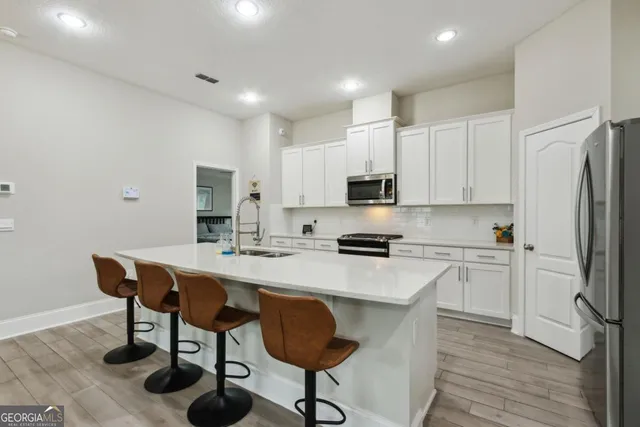 a kitchen with stainless steel appliances granite countertop white cabinets sink and a granite counter top