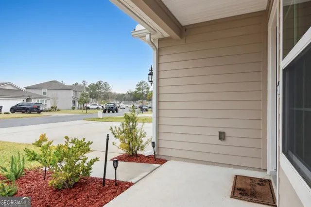 a kitchen with stainless steel appliances a stove a sink a refrigerator white cabinets and wooden floor