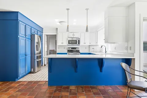 a kitchen with stainless steel appliances granite countertop a stove a sink and a refrigerator with wooden cabinets