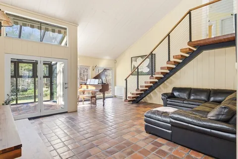 a living room with furniture oven and a floor to ceiling window