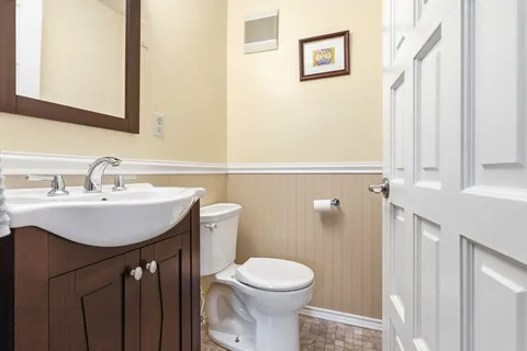 a bathroom with a sink mirror and toilet