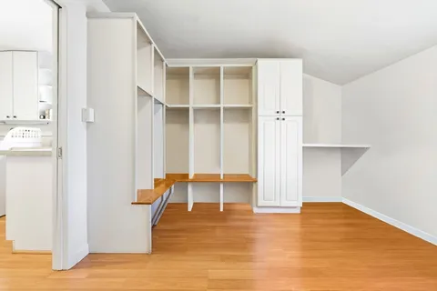 a view of a room with wooden floor and cabinet