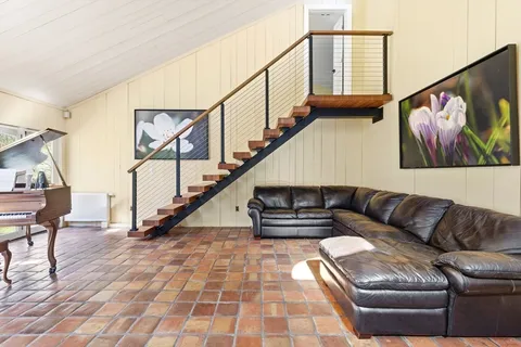 a living room with furniture and stairs