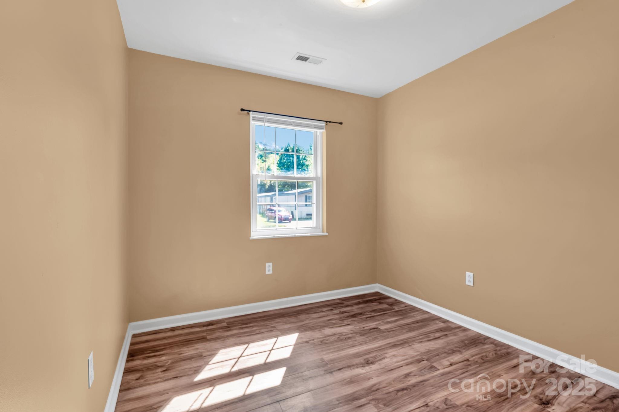 88 Lees Creek Road Asheville, NC 28806 - Photo 13 of 17 an empty room with wooden floor and windows