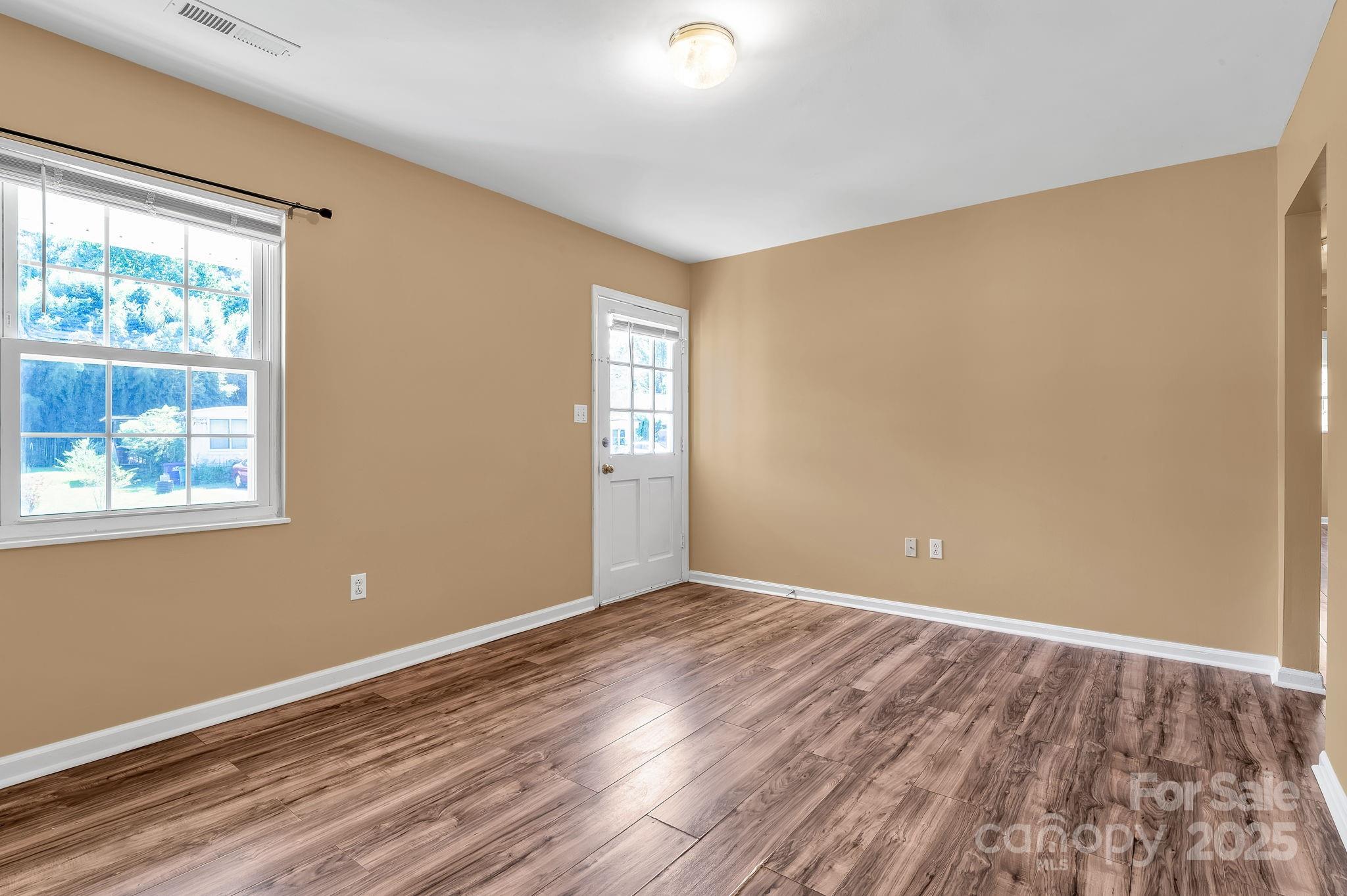88 Lees Creek Road Asheville, NC 28806 - Photo 4 of 17 a view of an empty room with window and wooden floor