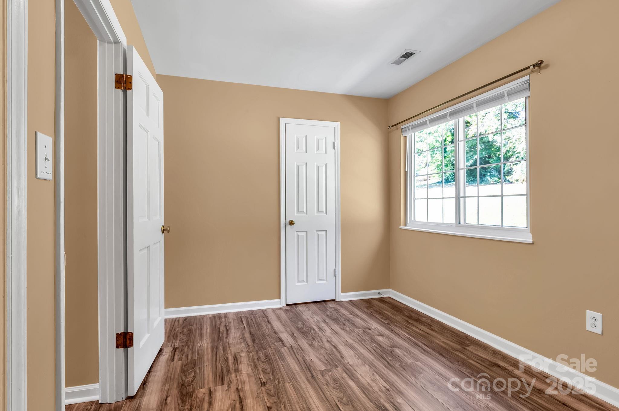 88 Lees Creek Road Asheville, NC 28806 - Photo 10 of 17 a view of an empty room with wooden floor and a window