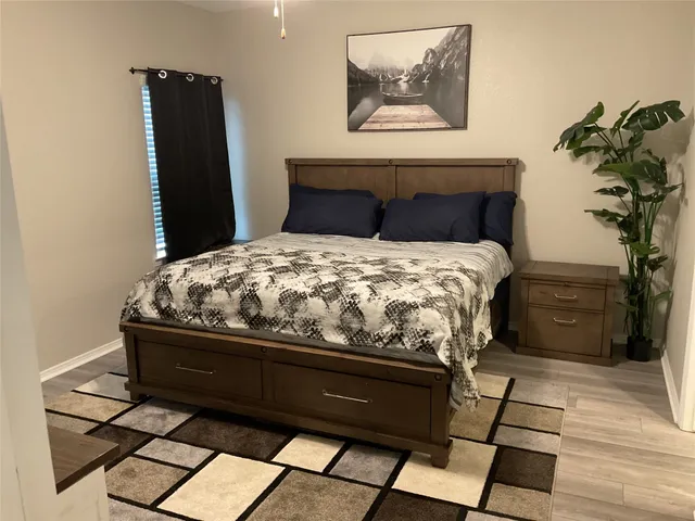 a bedroom with a bed and a potted plant