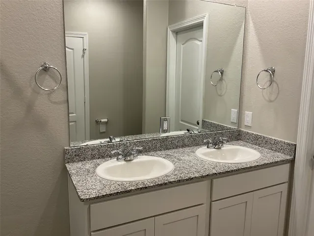 a bathroom with double sink and a mirror