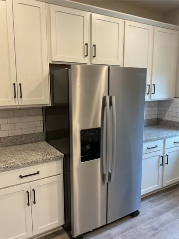 a metallic refrigerator freezer sitting in a kitchen