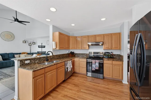 a kitchen with granite countertop a refrigerator and a sink