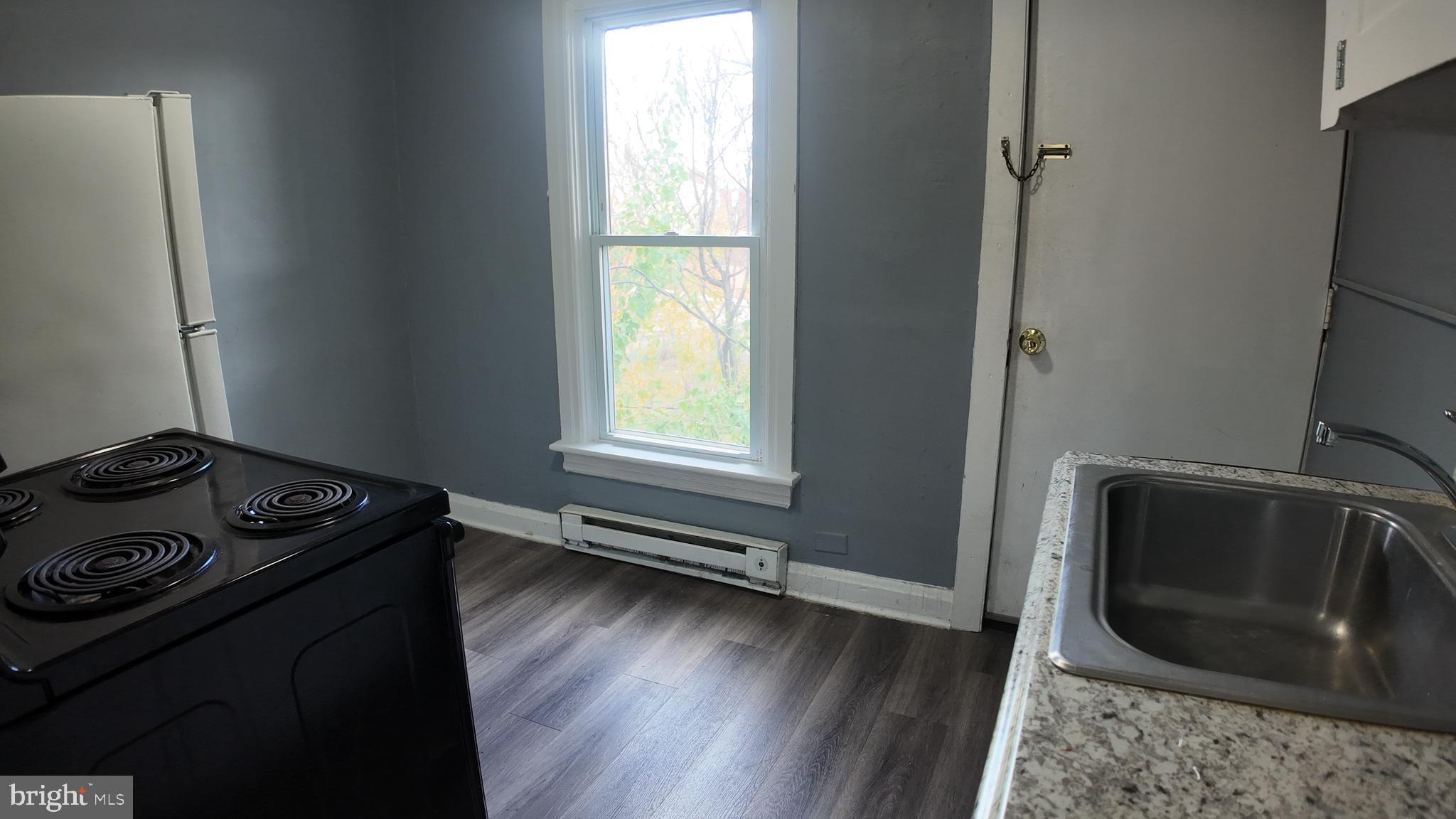 228 North Locust Street, Unit 4 Hagerstown, MD 21740 - Photo 2 of 16 a kitchen with a stove a microwave and a window