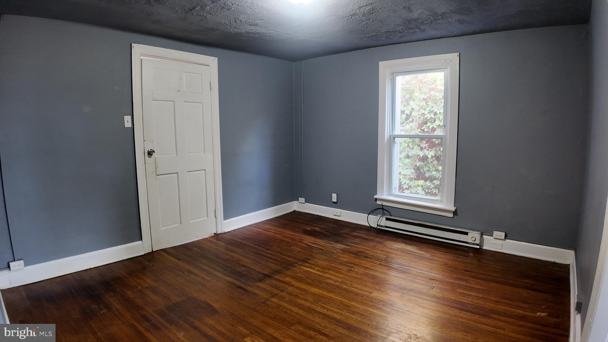 228 North Locust Street, Unit 4 Hagerstown, MD 21740 - Photo 4 of 16 an empty room with wooden floor and windows