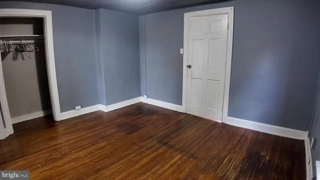 a view of a room with wooden floor and a wall