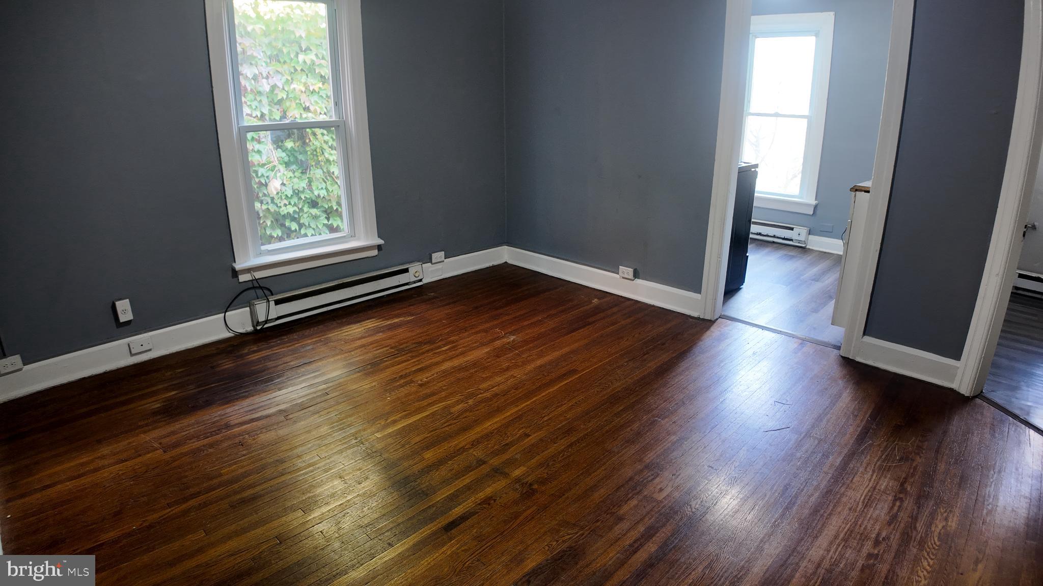 228 North Locust Street, Unit 4 Hagerstown, MD 21740 - Photo 6 of 16 an empty room with wooden floor and windows