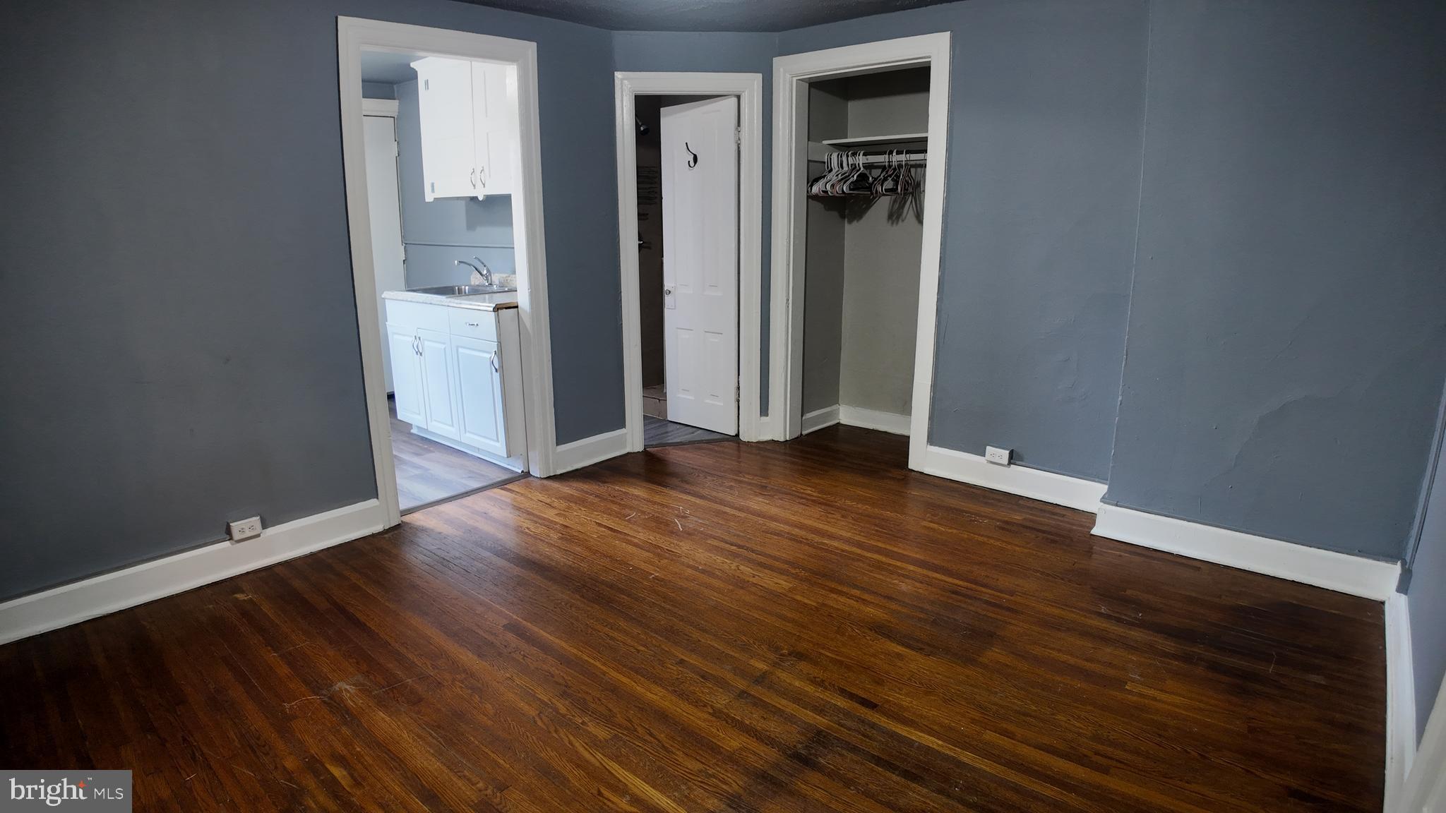 228 North Locust Street, Unit 4 Hagerstown, MD 21740 - Photo 7 of 16 an empty room with wooden floor and a mirror