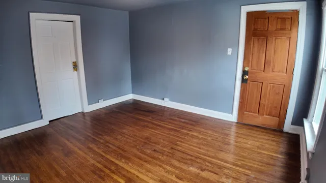 an empty room with wooden floor and closet