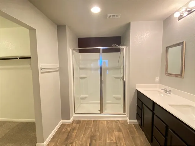a bathroom with a shower sink and mirror