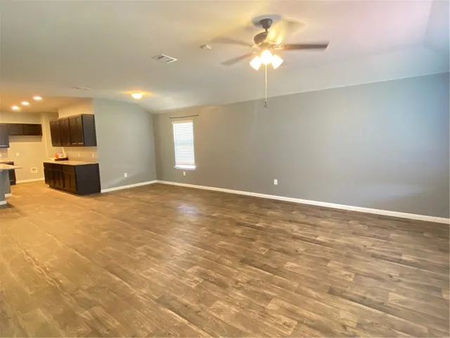 a view of a livingroom with a chandelier fan and a kitchen