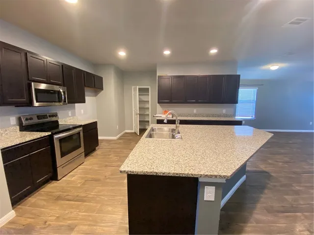 a kitchen with kitchen island a sink stainless steel appliances and cabinets