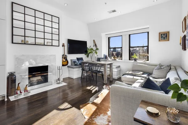a living room with furniture a flat screen tv and a fireplace