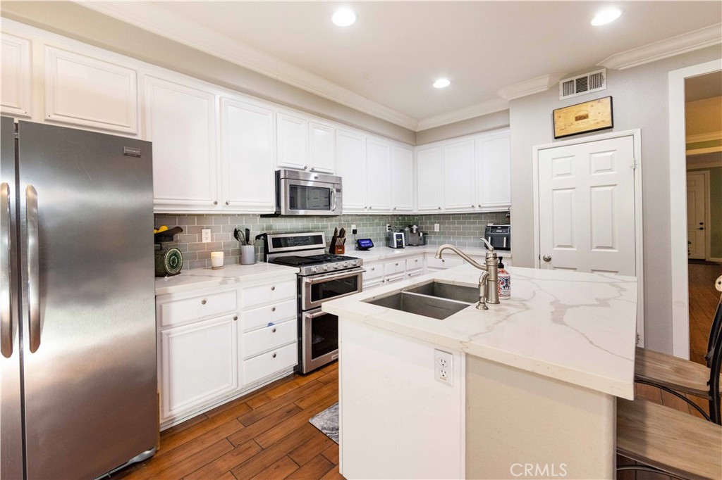 40232 Pasadena Drive Temecula, CA 92591 - Photo 14 of 44 a kitchen with a sink white cabinets and stainless steel appliances