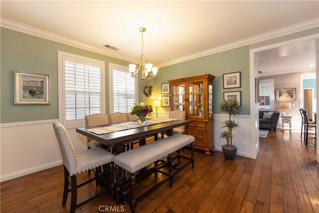 40232 Pasadena Drive Temecula, CA 92591 - Photo 7 of 44 a dining room with furniture wooden floor a rug a potted plant and a chandelier