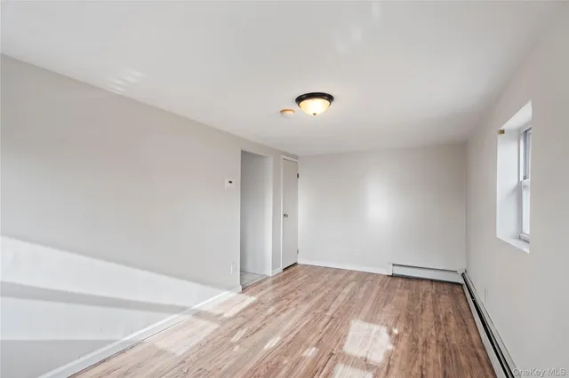 a view of a room with wooden floor and white walls