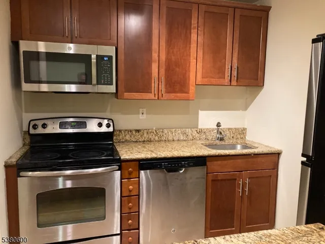 a kitchen with stainless steel appliances a stove a microwave sink and cabinets