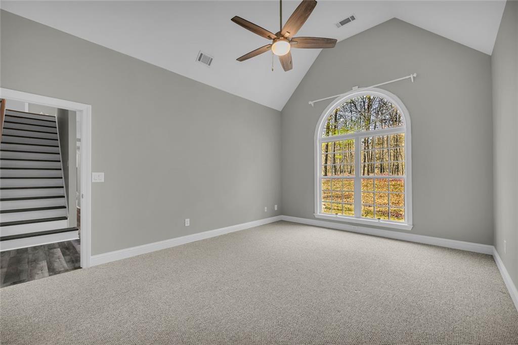 857 Cooper Road Social Circle, GA 30025 - Photo 23 of 88 an empty room with a window and a chandelier fan